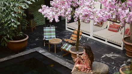 Tropisches Feeling, Frau sitzt am Pool und trinkt ein glas Champagner Tropisches Feeling, Frau sitzt am Pool und trinkt ein glas Champagner