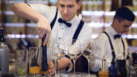 Barkeeper Mann erstellt einen Cocktail an der Bar
