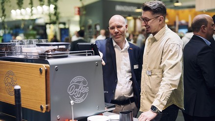 Kaffeemaschine Standbetreuer stehen vor einer Kaffeemaschine