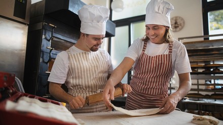 Behinderter Koch Behinderter Koch, backt mit einem Koch einen Pizzateig