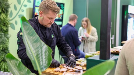 Showkoch Koch schneiden Speisen auf einem Holzbrett