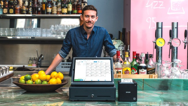 Mann hinter einer Kasse