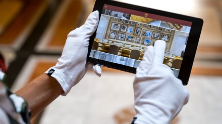 Person trägt mit Handschuhen ein Tablet Person trägt mit Handschuhen ein Tablet