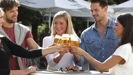Gruppe von Leuten steht zusammen und trinkt Bier Gruppe von Leuten steht zusammen und trinkt Bier