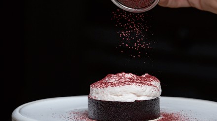 Dessert wird mit Schokoladenpulver gepudert Dessert wird mit Schokoladenpulver gepudert