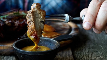 Gebratenes Fleisch wird in Senf getaucht Gebratenes Fleisch wird in Senf getaucht