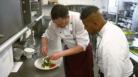 Koch zeigt Ben Brahim das anrichten eines Salates Koch zeigt Ben Brahim das anrichten eines Salates