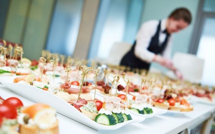 Eine Servicekraft beim Anrichten von kleinen Häppchen