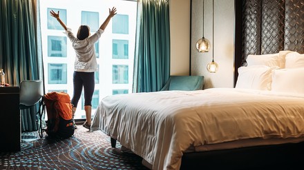 Frau streckt sich vor Fenster im Hotel