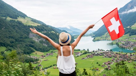 Touristin in der Schweiz mit Flagge in der hand