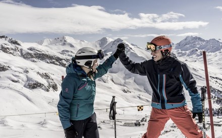 Zwei Skifahrer schlagen fröhlich die Hände zusammen