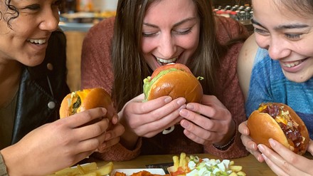 Drei Frauen essen Burger