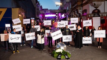 Olivia Jones und Teilnehmer einer Protestaktion halten Transparente