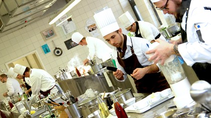 Mehrere Köche arbeiten in einer Großküche