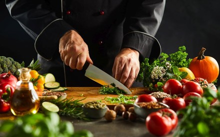 Koch beim Gemüse- und Kräuter-Schneiden