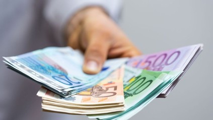 Mann hält Euro-Banknoten in der Hand