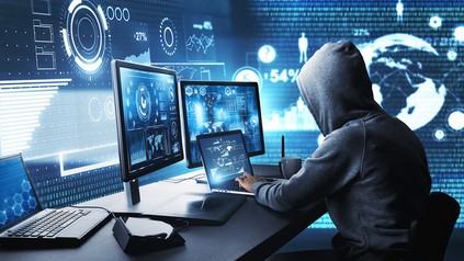 Eine vermummte Person an einem Computer