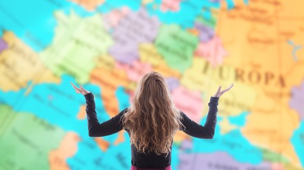 Frau steht vor einer Weltkarte