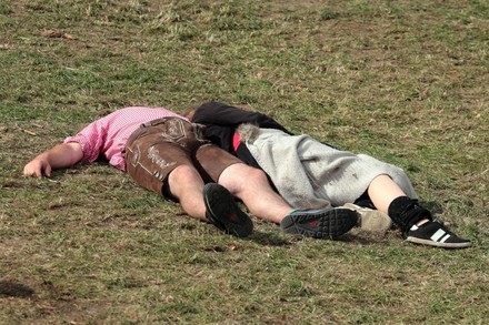 Mann in Tracht und Frau liegen auf der Wiese