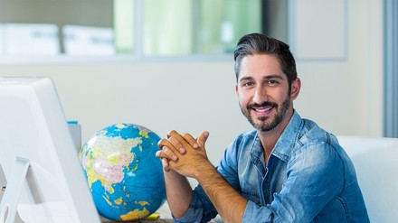 Reisebüromitarbeiter an seinem Schreibtisch