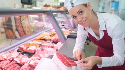 Eine Metzgereifachverkäuferin bei der Arbeit