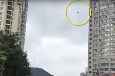 Mann seilt sich an Telefonkabel von Hochhaus