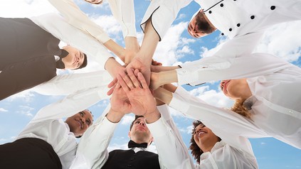 Mehrere Köche, die ihre Hände übereinander legen