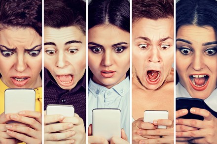 Erschrockene Blogger starren ungläubig auf ihr Handy