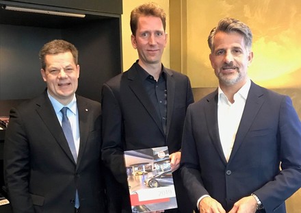 Drei Männer stellen neu erschienenen Marktbericht vor