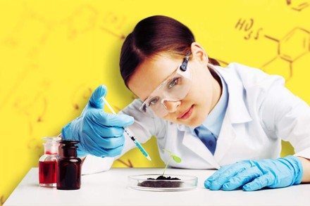 Kind spritzt Flüssigkeit aus Spritze in eine Petrischale mit Erde und Pflanze