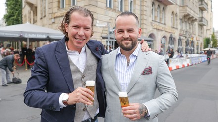 Jörn Peter Brinkmann (l) und Jan Philipp Bubinger (r), Geschäftsführer der „Ständigen Vertretung“, stehen anlässlich der 25-Jahr-Feier vor ihrer Kneipe. (Foto: © picture alliance/dpa | Jörg Carstensen)