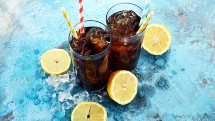 Zwei frische Gläser mit Cola, Eiswürfen und Zitronen