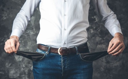 Mann zeigt seine leeren Hosentaschen