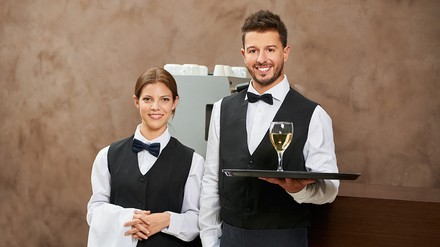 Kellner und Kellnerin servieren Weißwein