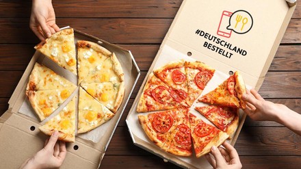 Pizza in geöffneten Pizzaschachteln, von denen sich mehrere Leute etwas herausnehmen, #DeutschlandBestellt
