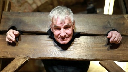 Mann in einem hölzernen Pranger