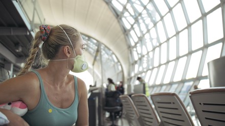 Eine Frau mit Mundschutz am Flughafen