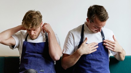 Zwei Köche beim Anziehen ihrer Berufskleidung