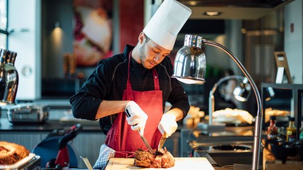 Koch beim Zubereiten von Fleisch