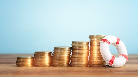 Gestapelte Münzen mit Rettungsring