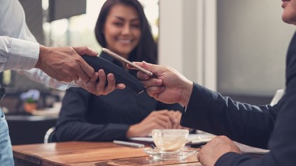 Restaurantgast bezahlt seine Rechnung via Handy