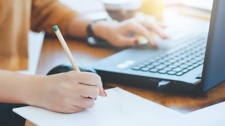 Seminarteilnehmer sitzt vor Laptop und macht sich Notizen