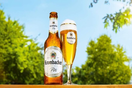 Eine Flasche und ein Glas mit Krombacher Pils