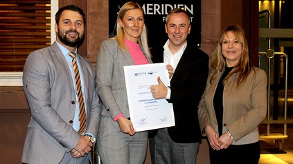 Eine Gruppe Le Meridien-Mitarbeiter mit Urkunde in der Hand