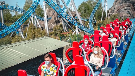 Fahrgäste in einer Achterbahn im Europa-Park in Rust tragen eine Mund-Nasen-Maske