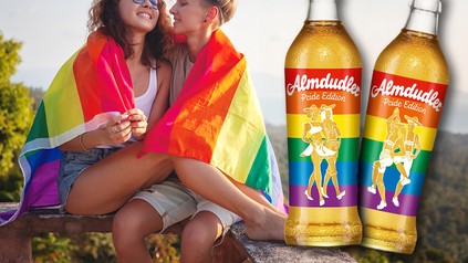 Ein lesbisches Paar und zwei Almdudler-Flaschen