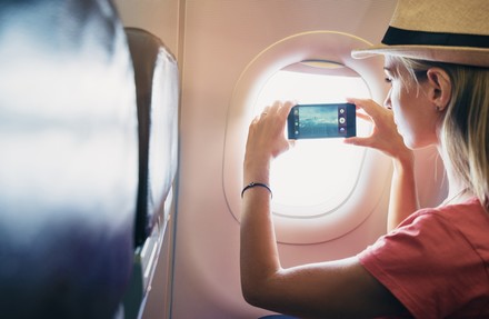 Frau fotografiert aus einem Flugzeugfenster hinaus