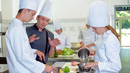 Ausbilder gibt auszubildenden Köchen Anleitungen