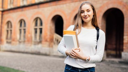 Junge Frau mit Büchern unter dem Arm