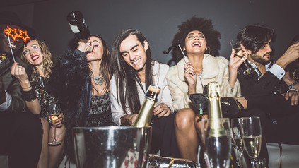 Freunde feiern augelassen mit Sekt oder Champagner in einem Club oder in einer Diskothek